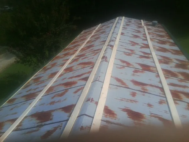 Rusted metal roof panels with new wood purlins before replacement — Storm Damage Roof Repair in Shelley by Roofing Brothers