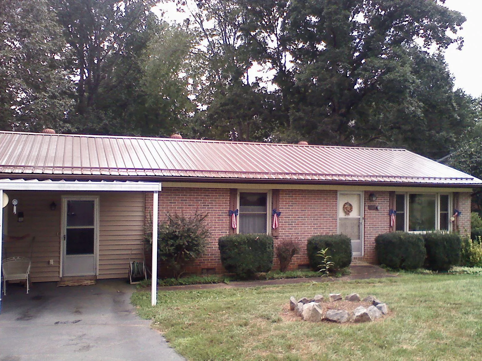 Bronze metal roof and carport on a brick ranch home — Roof Repair work by our crew in Shelley