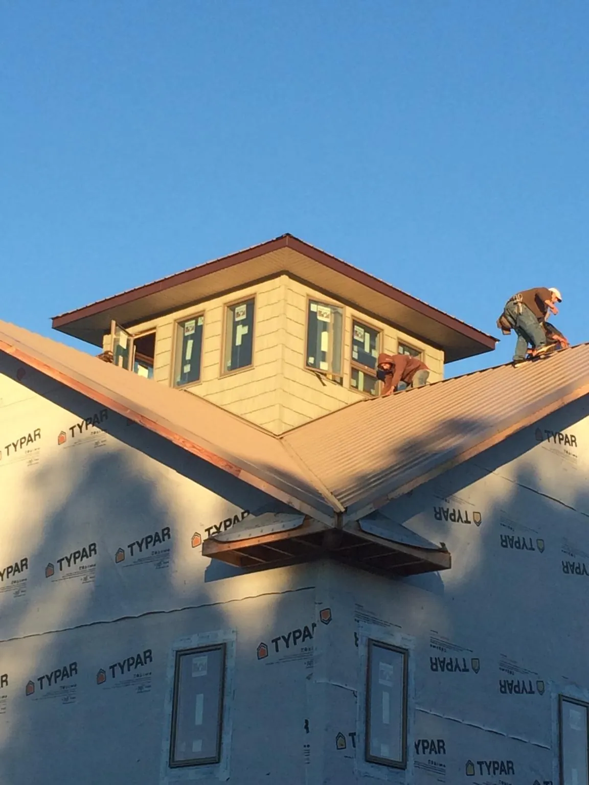 Roofers working around a rooftop cupola on a new metal roof at sunset — Roof Waterproofing in Shelley by Roofing Brothers